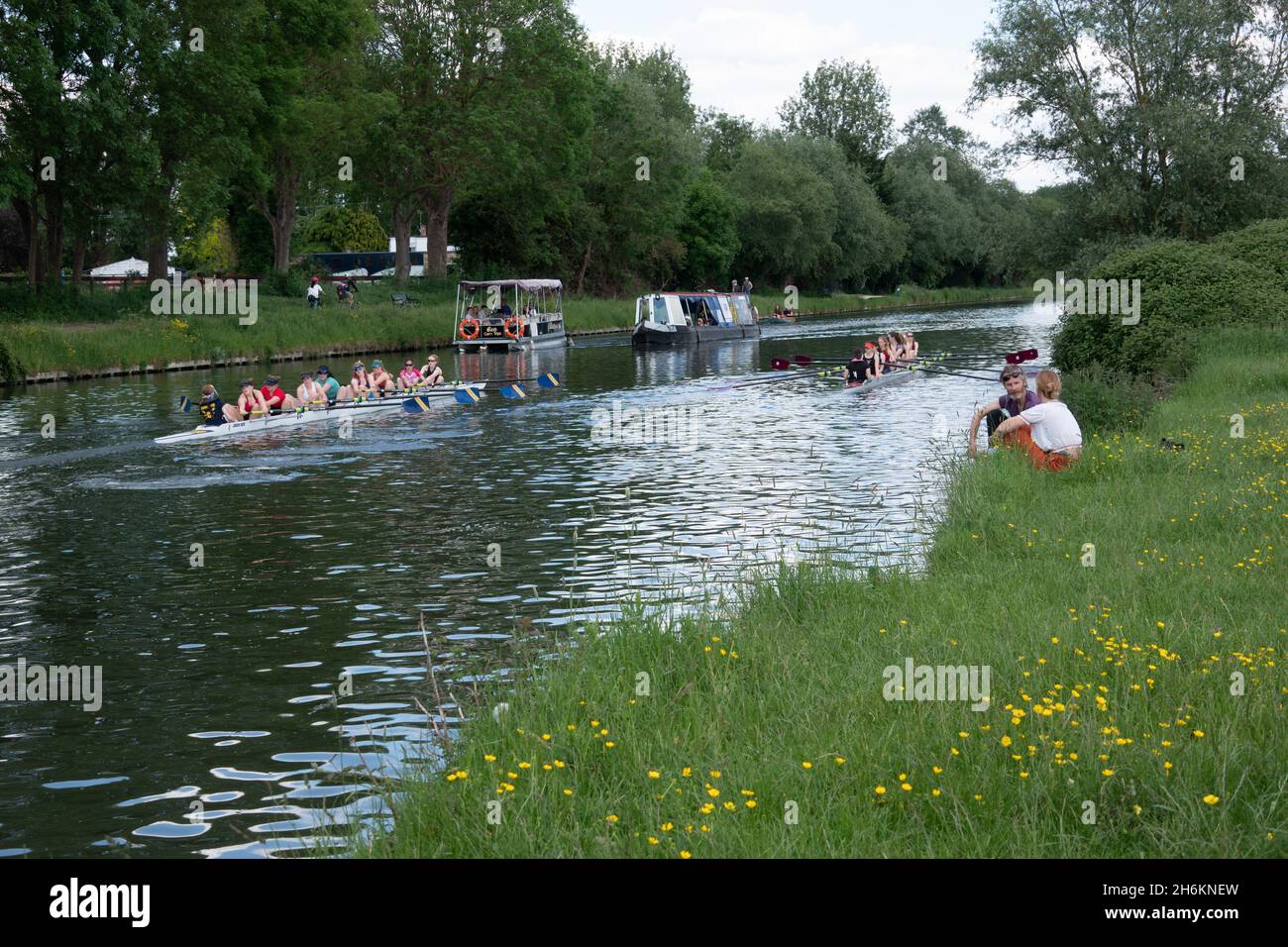 Paar sitzen entspannt am Flussufer neben dem River Cam in der Nähe von Cambridge mit Rudern auf dem Eight River Stockfoto