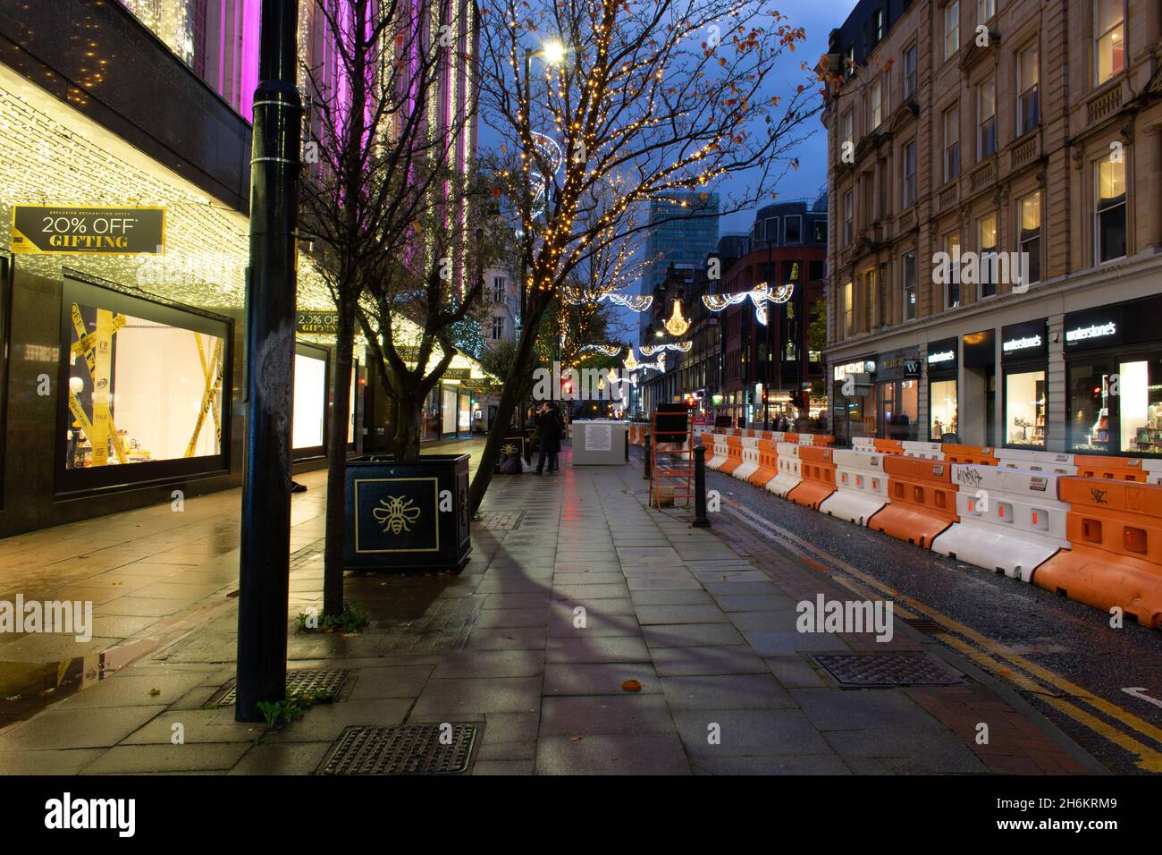 Deansgate Verschmutzungskontrolle Fußgängerzone mit Verkehrsbarrieren und Weihnachtsbeleuchtung. Langzeitbelichtung. Manchester, Großbritannien. Stockfoto