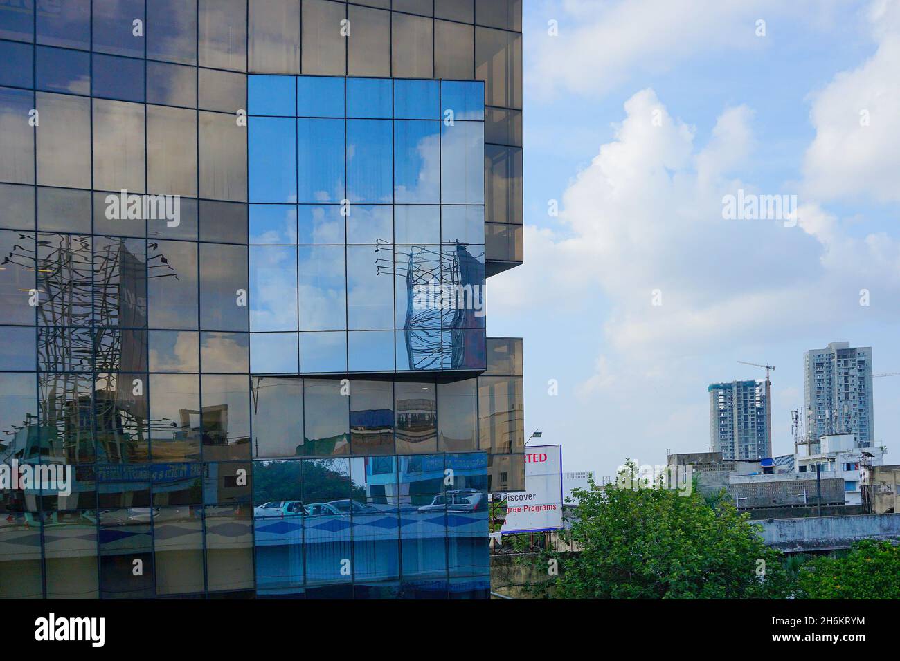 Kalkutta, West Bengal, Indien - 20. Juli 2019 : Moderne Architektur von Gebäuden, Glas außen reflektiert blauen Himmel, weiße Wolken und andere Gebäude. Stockfoto