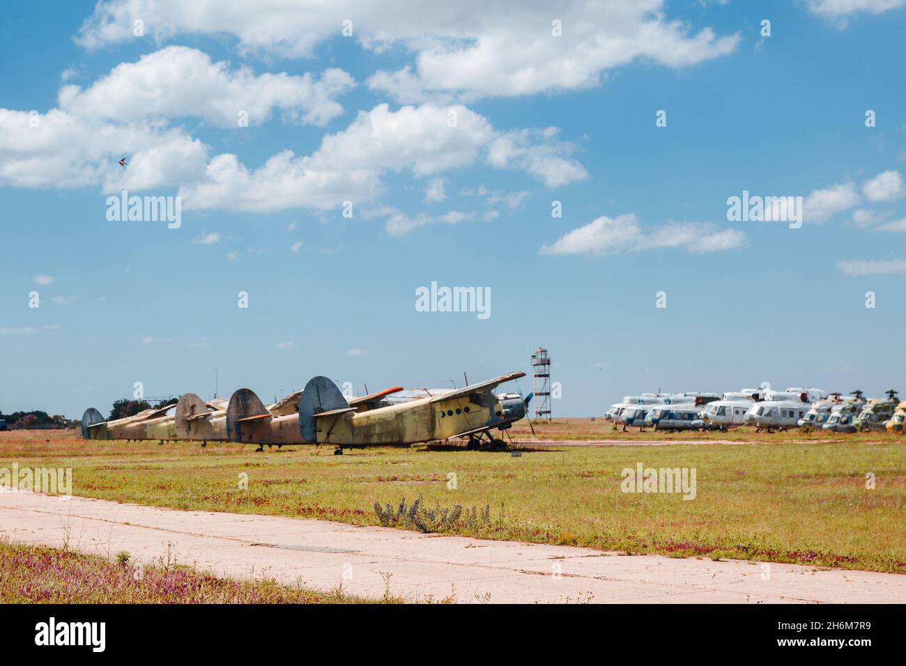 Alte zerstörte verlassene Flugzeuge und Hubschrauber auf dem Feld, Friedhof von alten Hubschraubern und Flugzeugen. Stockfoto