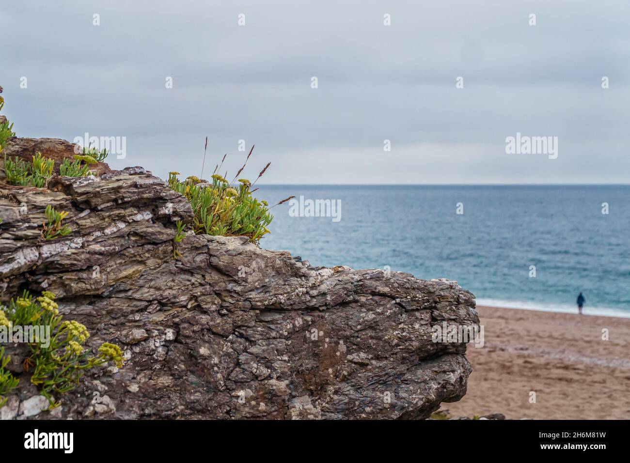 Kaukasischer Mann, der einen ruhigen Spaziergang am Strand macht, Cornwall, Großbritannien Stockfoto