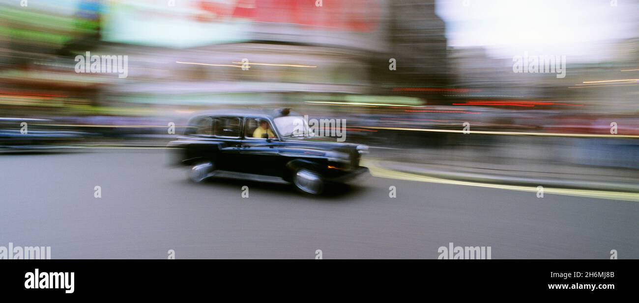 Verschwommene Bewegung des Taxis auf der Straße am Piccadilly Circus London, England Stockfoto