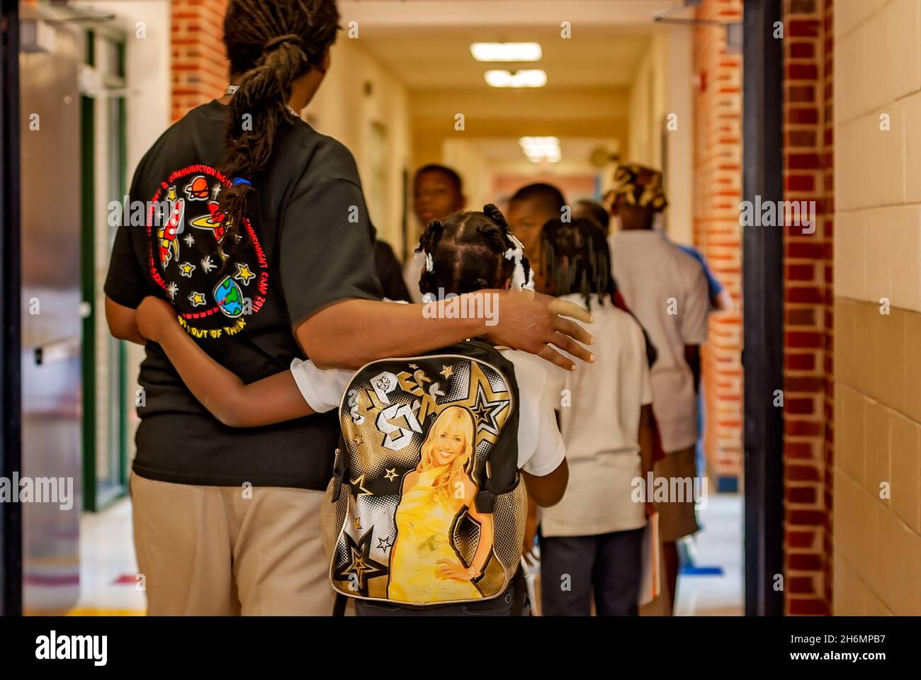 Eine Grundschullehrerin umarmt einen Schüler Auf Wiedersehen, als sie am letzten Schultag, dem 13. Juni 2011, in Columbus, Mississippi, die Halle hinuntergehen. Stockfoto