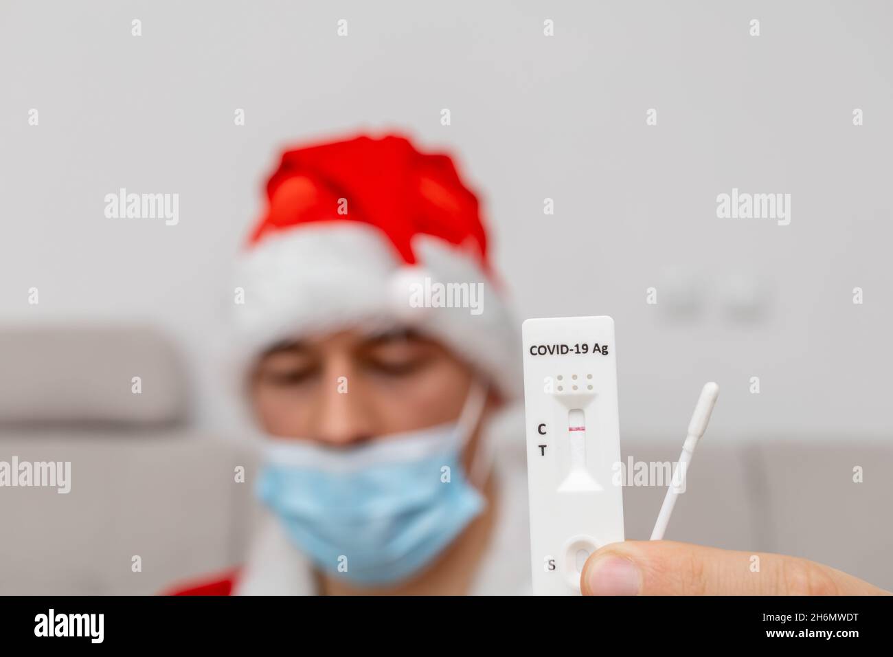 Mann mit Weihnachtsmannhut, der das Testergebnis zeigt Stockfoto