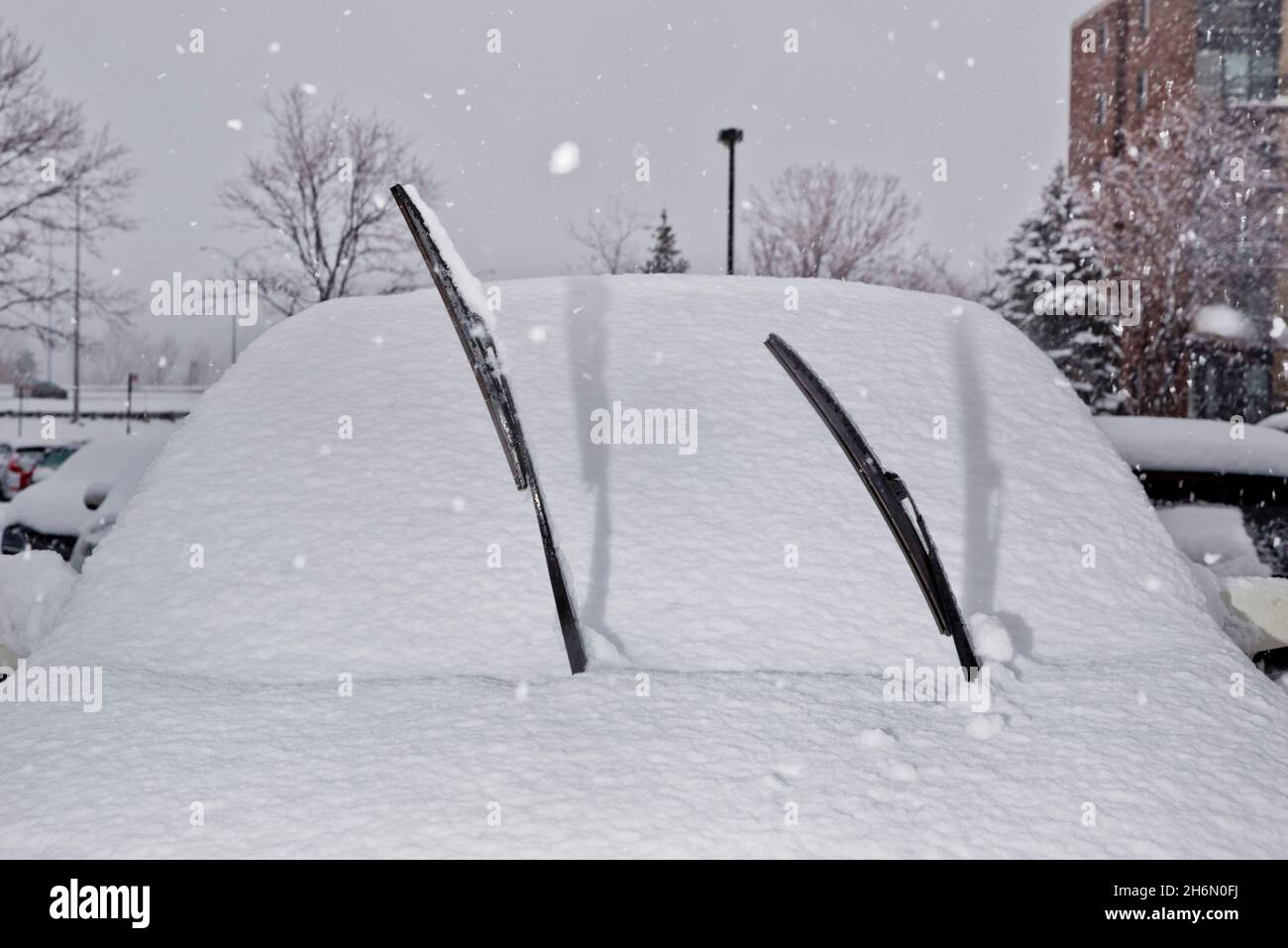 Windschutzscheibenwischer, die während des Winters in Longueuil, Quebec, Kanada, von einem schneebedeckten Auto aufstehen. Stockfoto