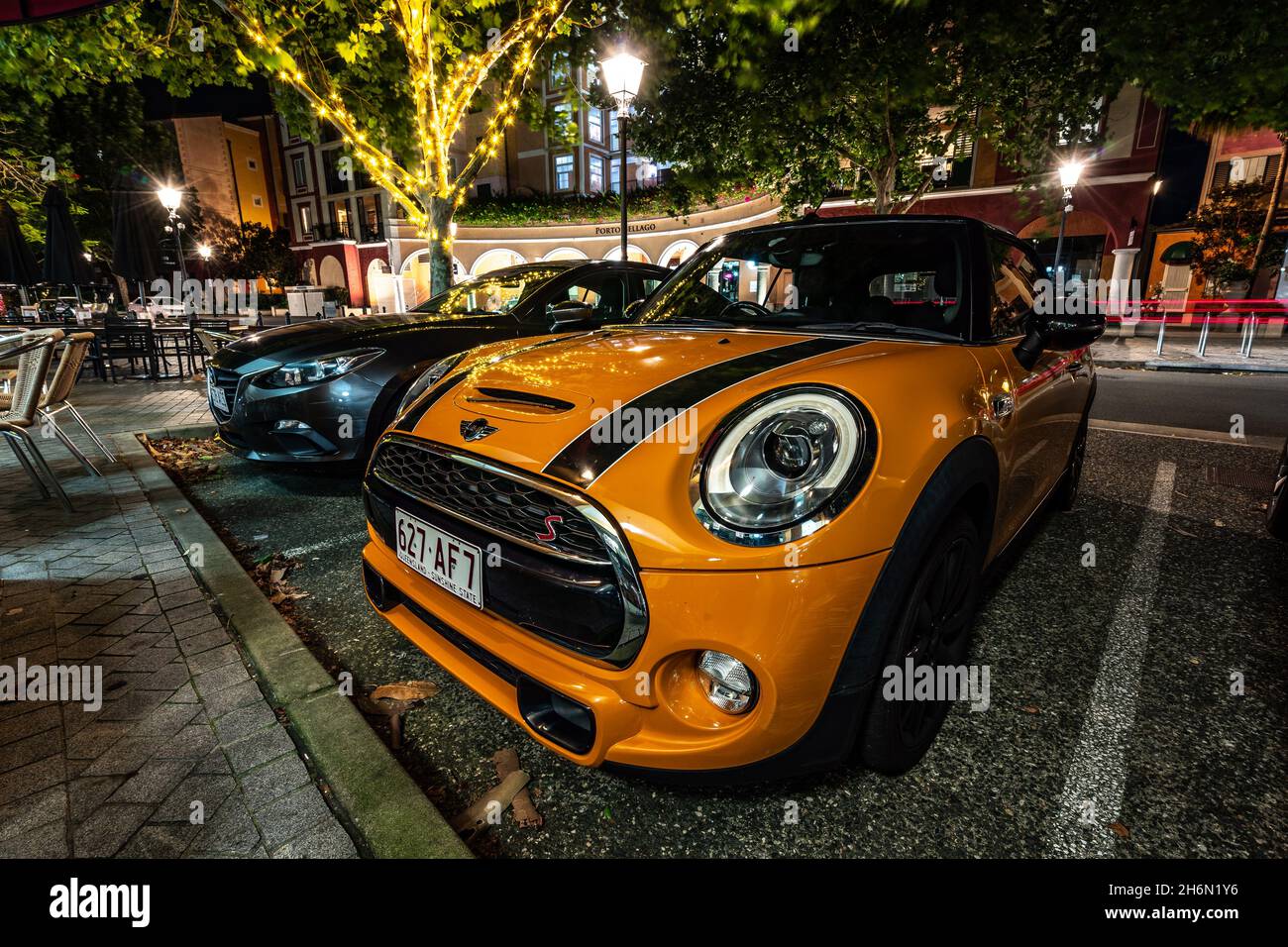 Gold Coast, Queensland, Australien - Mini Cooper, der nachts unter bunten Lichtern geparkt wird Stockfoto