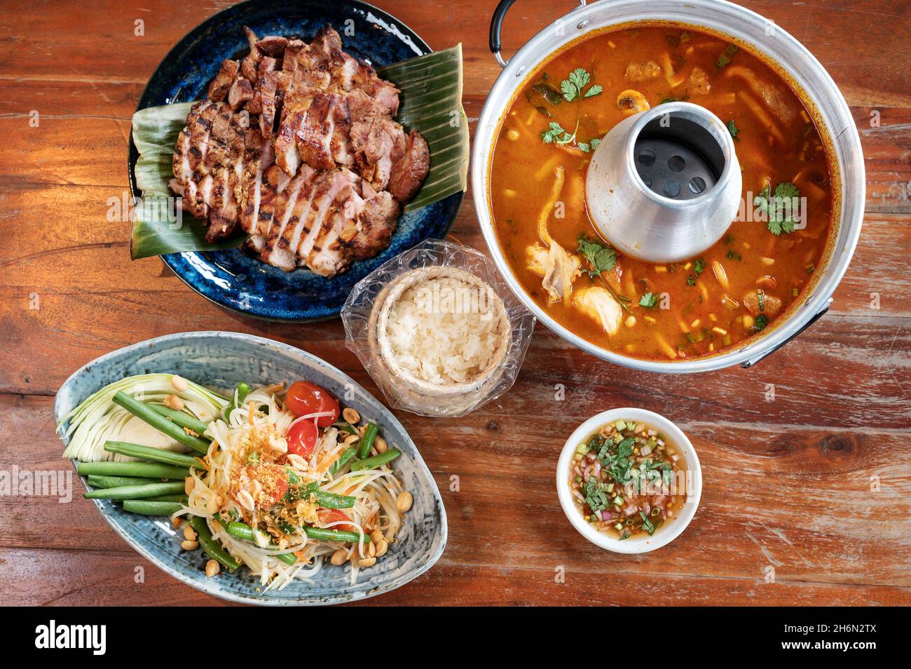 Thailändische Speiseplatte in einem thailändischen Restaurant. Grüne Bohnen, Bohnensprossen, Erdnusssoße, gegrilltes Schweinefleisch. Stockfoto