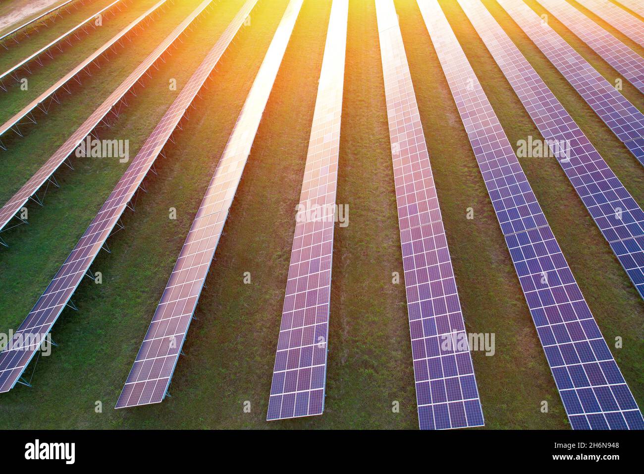 Solarkraftwerkspaneele im Feld mit dem Glanz der Abendsonne in Solarzellen. Stockfoto