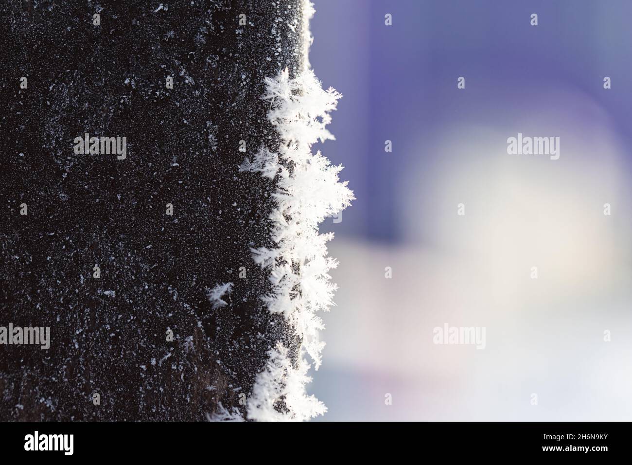 Metallstange mit Frost bedeckt mit Schneeflocken. Russland, Winter. Stockfoto