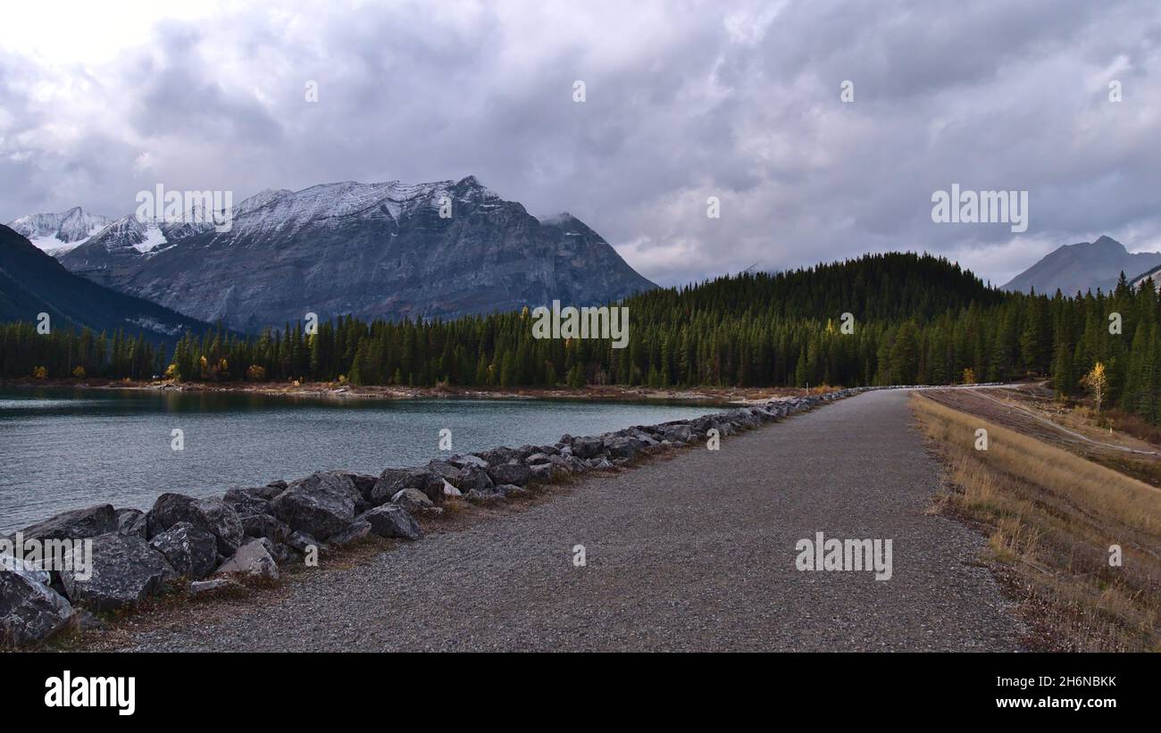 Schöner Blick auf den Stausee Upper Kananaskis Lake in den Rocky Mountains in Alberta, Kanada in der Herbstsaison an bewölktem Tag mit Staudamm und Wald. Stockfoto