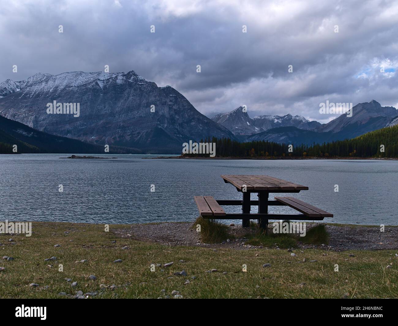 Blick auf den Stausee Upper Kananaskis Lake in Alberta, Kanada in den Rocky Mountains in der Herbstsaison mit Picknicktisch am Ufer. Stockfoto