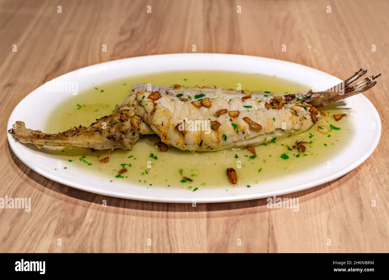 Bacalao mit Pil-Pil-Sauce, traditionelles baskisches Gericht mit Salzcod in Knoblauch-Öl mit getrockneter guindilla-Chili, in einem Restaurant in Pamplona, Spanien Stockfoto