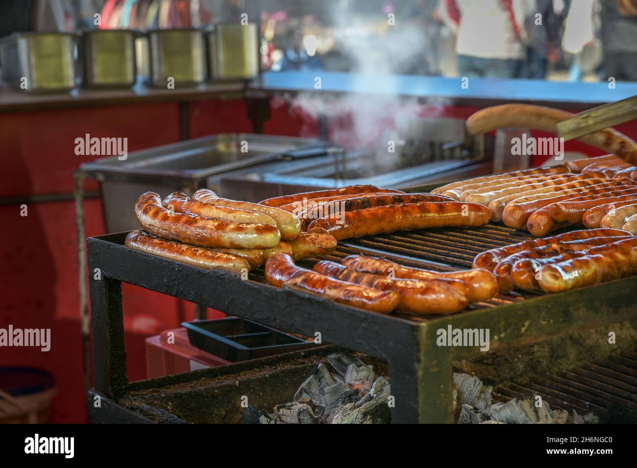 Heiße Würstchen auf dem Straßengrill, typisches Fast Food auf einem deutschen Jahrmarkt oder Weihnachtsmarkt, ausgewählter Fokus, enge Schärfentiefe Stockfoto