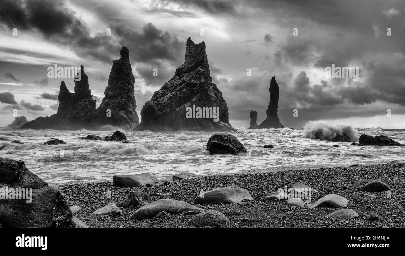 Lavagestein und Felsennadeln am schwarzen Lavastrand Reynisfjara, Reynisdrangar, Vik, Südisland, Island Stockfoto