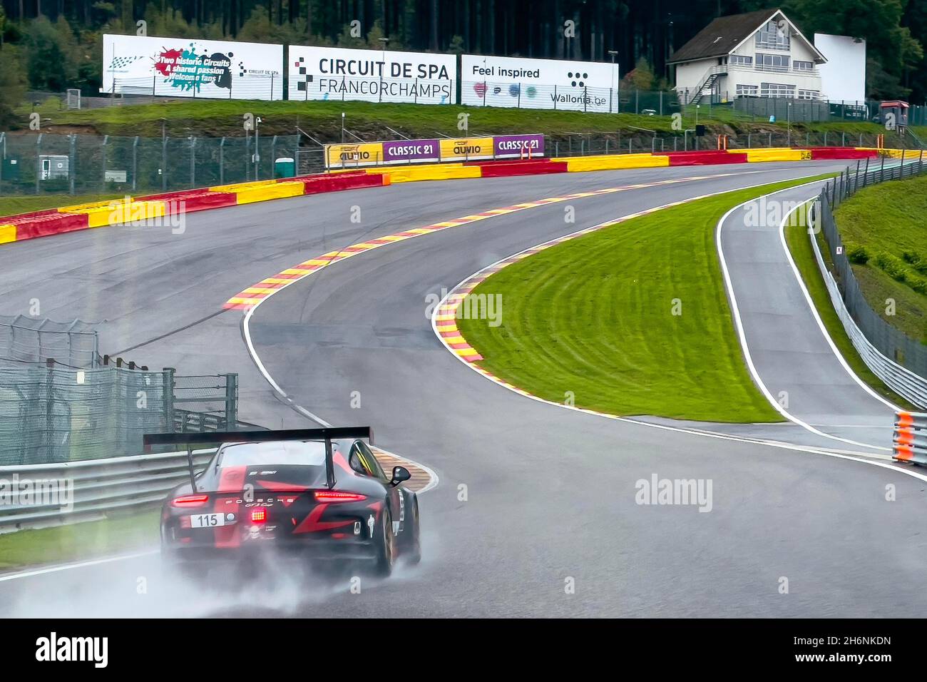 Der Porsche GT3 Cup-Rennwagen fährt an der Ecke Eau Rouge von der Raidillon Slip Road, Circuit de Spa-Francorchamps, Stavelot, Belgien, auf die nasse Rennstrecke Stockfoto