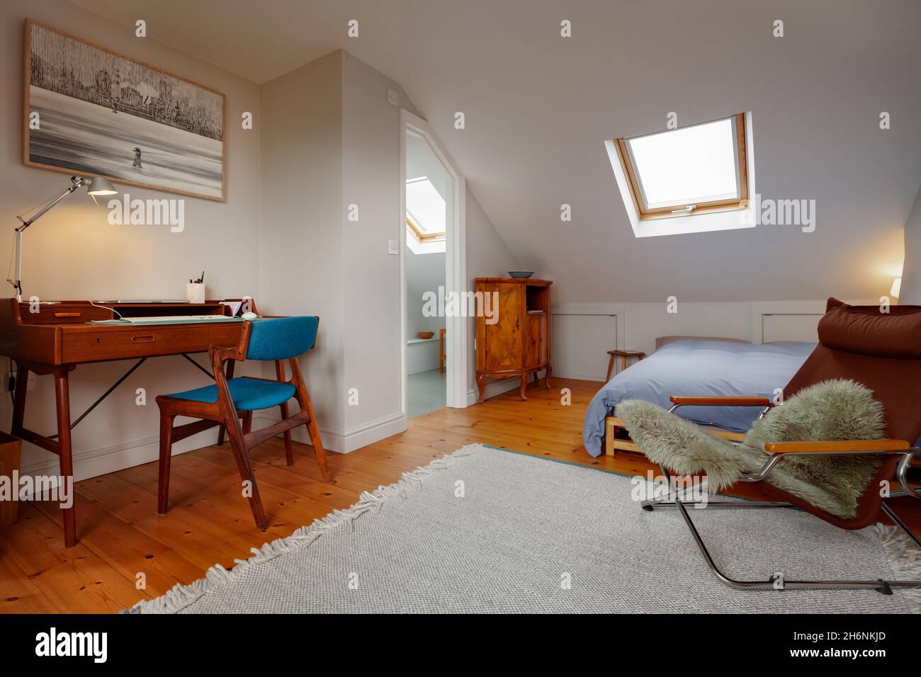 Cambridge, England - Oktober 11 2019: Schlafraum im Loft-Stil mit Holzdielen mit Schreibtisch, Sessel und Bett. Stockfoto
