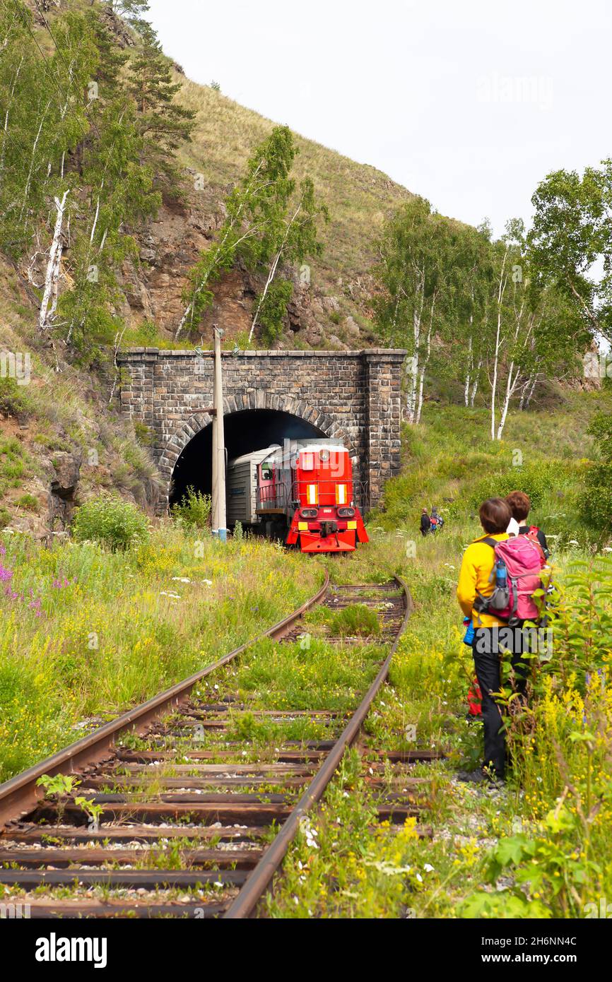 Wanderer und eine Eisenbahn auf der alten Strecke der Transsibirischen Eisenbahn, Provinz Irkutsk, Russland Stockfoto