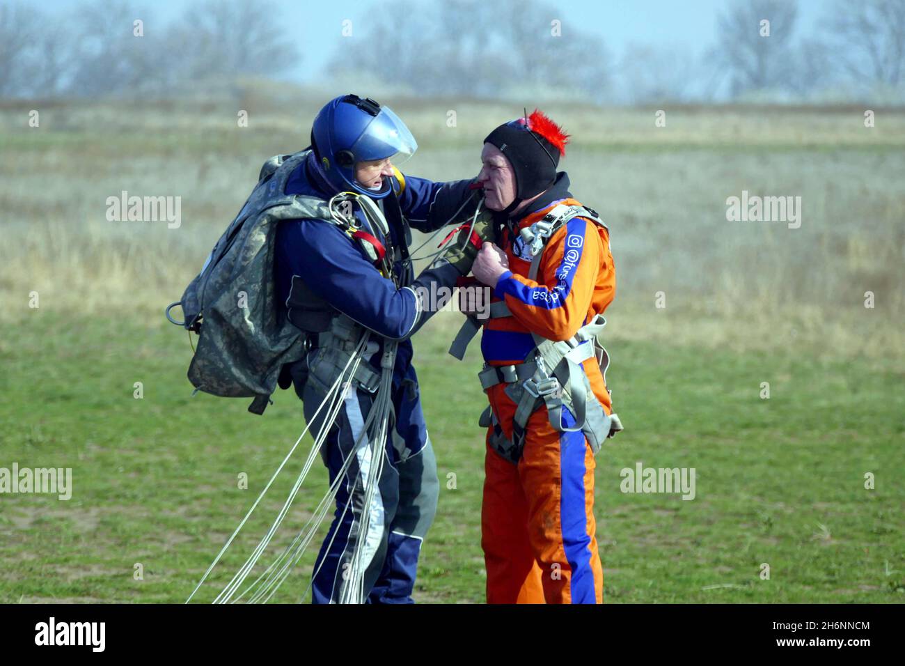 ODESA, UKRAINE - 16. NOVEMBER 2021 - ein Ausbilder hilft einem Mann nach einem Tandemsprung beim Fallschirmspringen im Odesa Flying Club, Odesa, Stockfoto