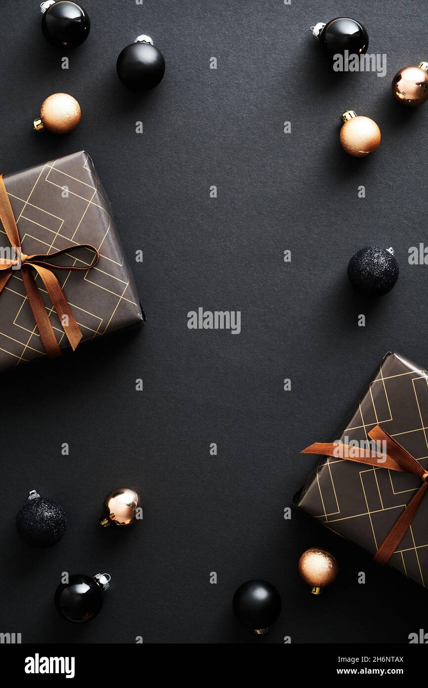 Vertikale Weihnachten Hintergrund mit Weihnachtsgeschenken und Kugeln Dekoration. Dunkles, elegantes Weihnachtsbanner für Social-Media-Geschichten. Stockfoto