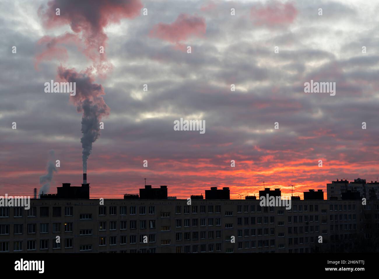 Wirbelnder Rauch über dem Rohr eines thermischen Kraftwerks während einer schönen Morgendämmerung (St. Petersburg, Russland) Stockfoto