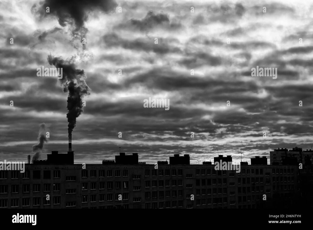 Schwarz-Weiß-Konzept einer urbanen Landschaft mit Dampf-Emission aus einem Rohr und einem Schlafbereich (St. Petersburg, Russland) Stockfoto