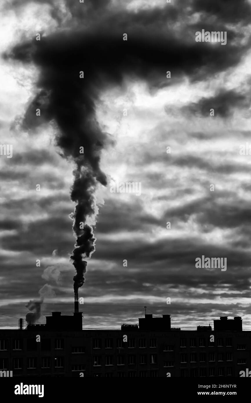 Schwarz-Weiß-Konzept Schwarzer Dampf Emission über dem Rohr eines thermischen Kraftwerks mit dramatischem Himmel (St. Petersburg, Russland) Stockfoto