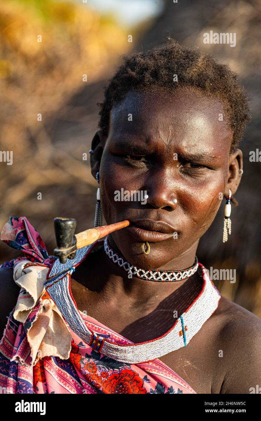 Frau aus dem Stamm der Toposa, die eine Pfeife raucht, Eastern Equatoria, Südsudan Stockfoto