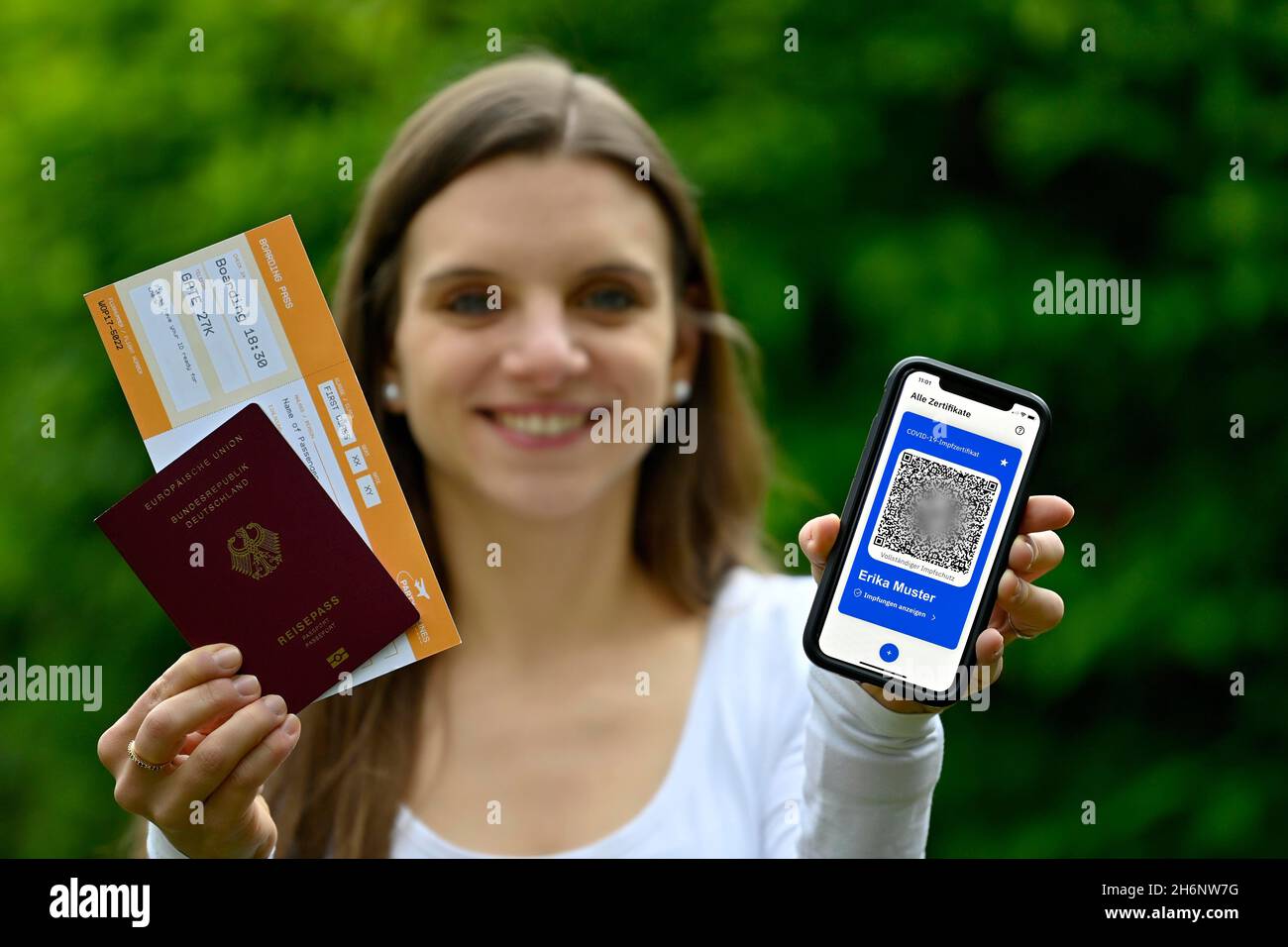 Symbol Foto Impfprivilegien, junge Frau mit App CovPass auf dem Smartphone mit digitalem europäischen Impfpass inklusive QR-Code Stockfoto