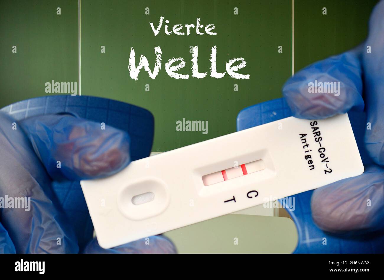 FOTOMONTAGE, positiver Antigenschnelltest, Tafel mit Aufschrift VIERTE WELLE, Klassenzimmer, Corona-Krise, Deutschland Stockfoto