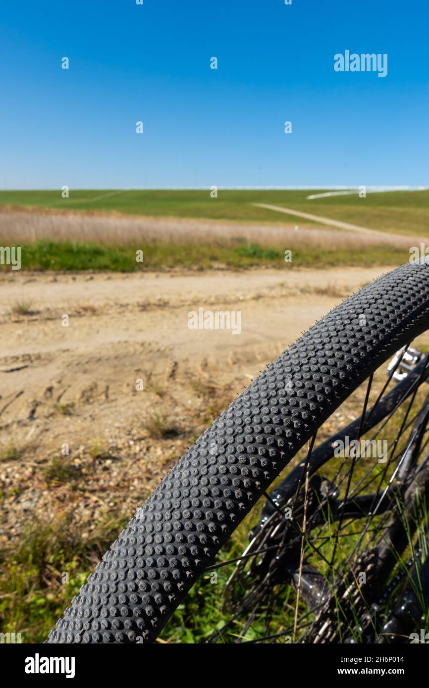 Nahaufnahme eines Schotterradreifens. Abenteuer auf einem naturgetreuen Fahrrad. Foto aufgenommen an einem schönen sonnigen Tag. Stockfoto
