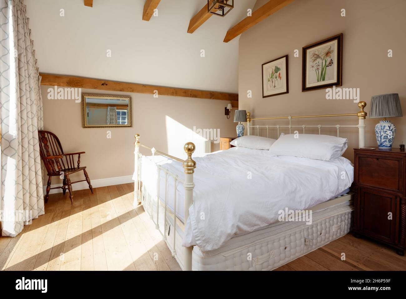 Stoke by Clare, England Oktober 17 2019: Schlafzimmer im traditionellen englischen Cottage mit freiliegenden Balken, Bett und abfallender Decke Stockfoto