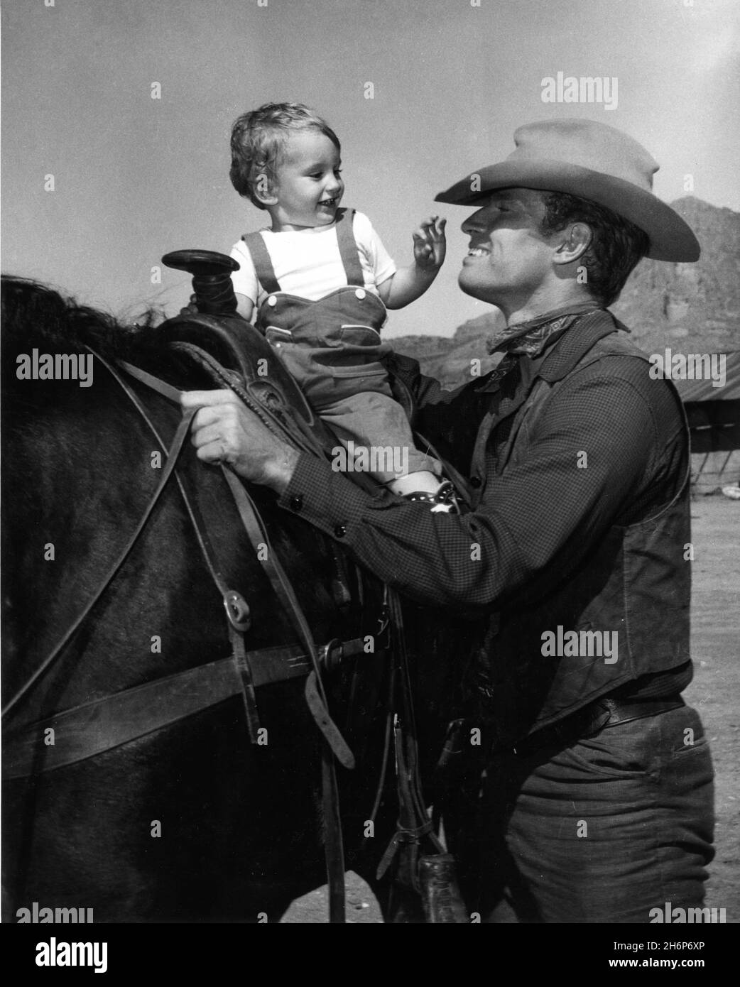 CHARLTON HESTON mit seinem einjährigen Sohn FRASER HESTON am Drehort in Arizona während der Dreharbeiten von DREI GEWALTTÄTIGEN MENSCHEN 1956 Regisseur RUDOLPH MATE / MATÉ Kostümbild Edith Head Paramount Picturms Stockfoto
