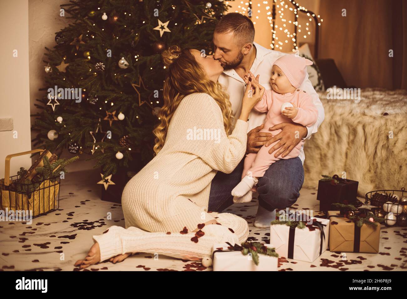 Küssen Eltern und Baby zu Weihnachten. Stockfoto