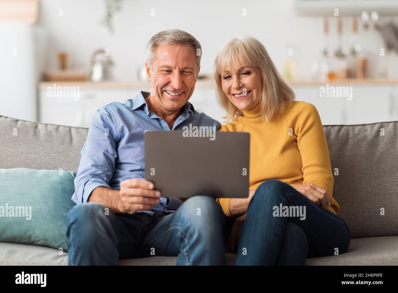 Happy Älteres Paar Mit Laptop Browsing Internet Zusammen Zu Hause Stockfoto