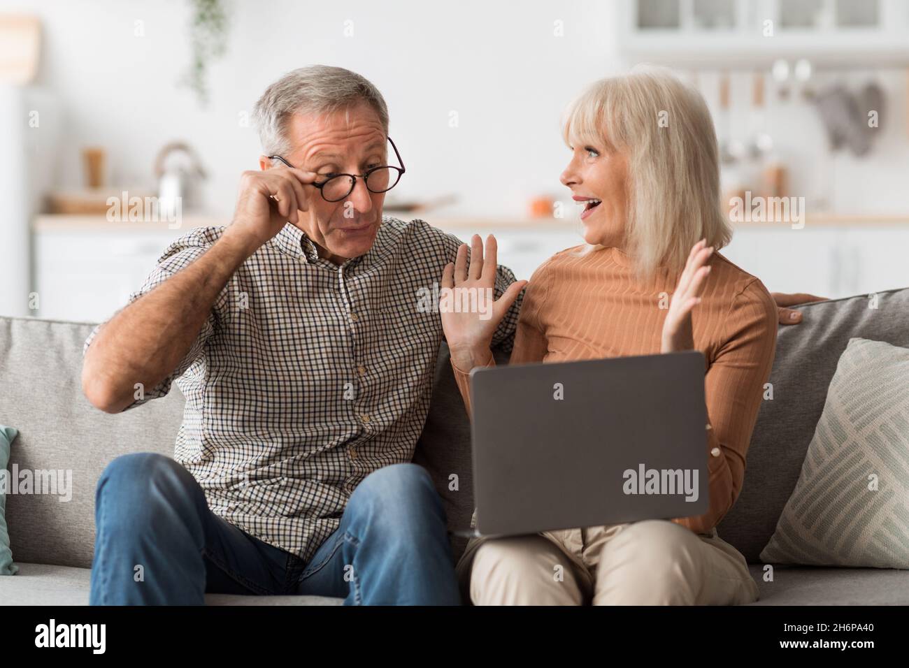 Fröhliche Ältere Ehepartner, Die Laptop Betrachten Und Den Erfolg Zu Hause Feiern Stockfoto