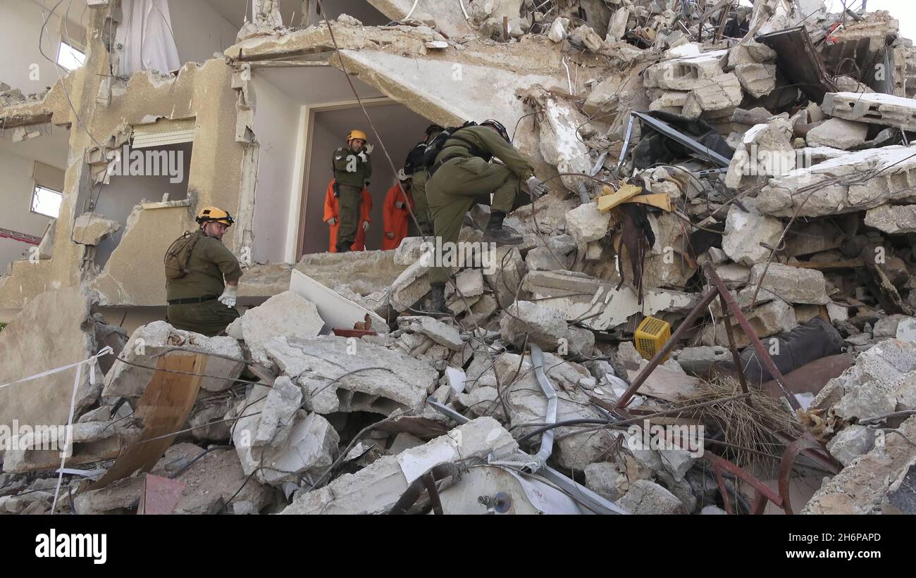 Israelische Soldaten der Rettungseinheit des Kommandos der Heimatfront gehen durch die Trümmer eines eingestürzten Gebäudes, während sie am 16. November 2021 in Tel Aviv, Israel, an einer Such- und Rettungsübung an einem großen Abrissplatz teilnehmen. Die Home Front-Übung simulierte Such- und Rettungsaktionen, die sich auf Szenarien vorbereiten, die Gebäude zerstören und Bürger aufgrund eines schweren Erdbebens oder massiver Raketeneinschläge einfangen könnten. Stockfoto