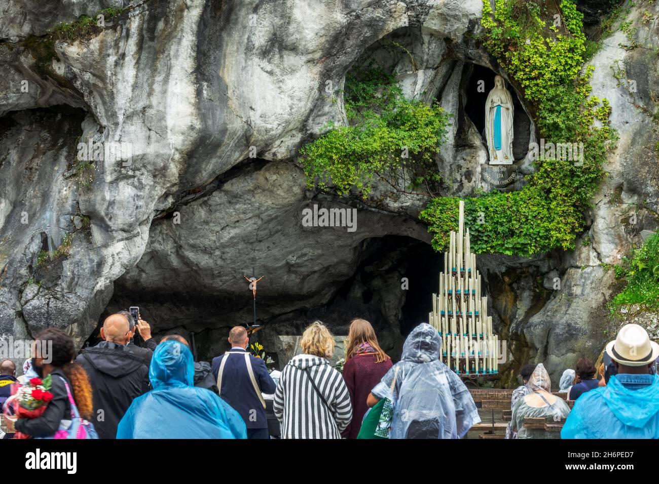 Pilger beten in der Grotte unserer Lieben Frau von Lourdes, Frankreich, um die Statue der Jungfrau Maria Stockfoto