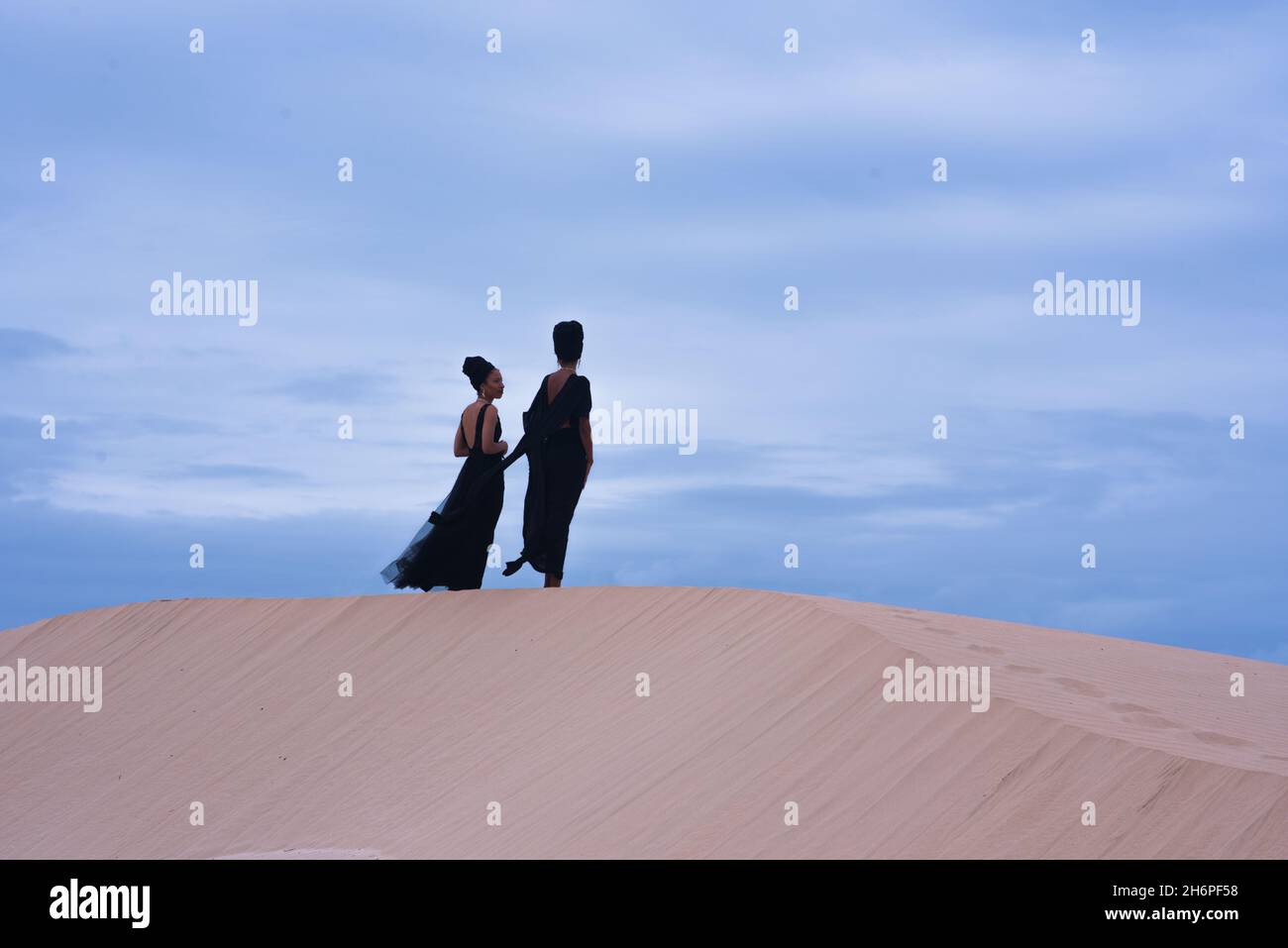 Frau auf Sanddüne mit klarem Himmel stehend gesehen Stockfoto