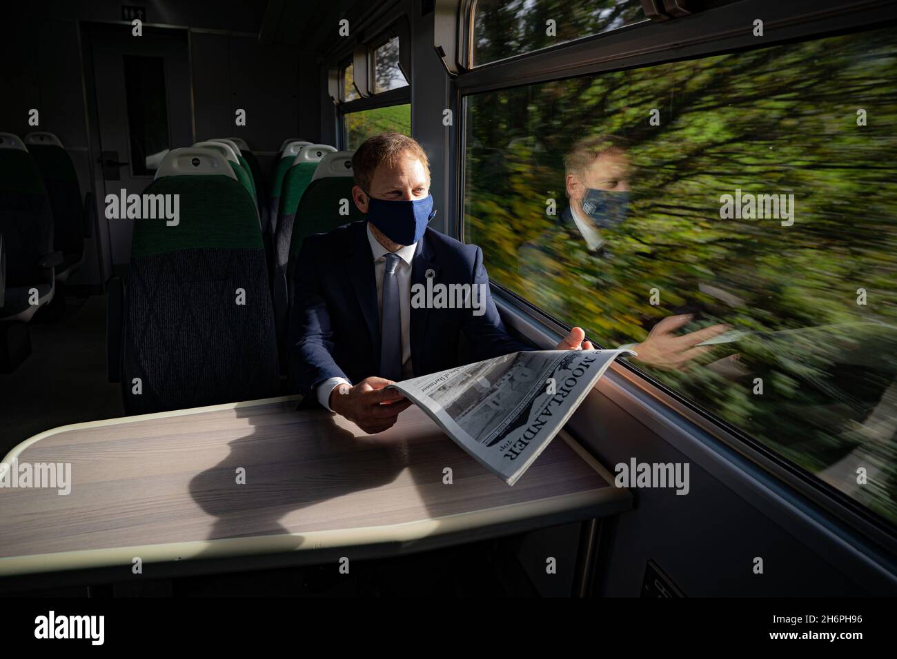 Verkehrsminister Grant Shapps liest die Moorlander-Zeitung, als er mit der neu eröffneten Dartmoor-Linie am Bahnhof Crediton den ersten Zug fährt. Bilddatum: Mittwoch, 17. November 2021. Stockfoto