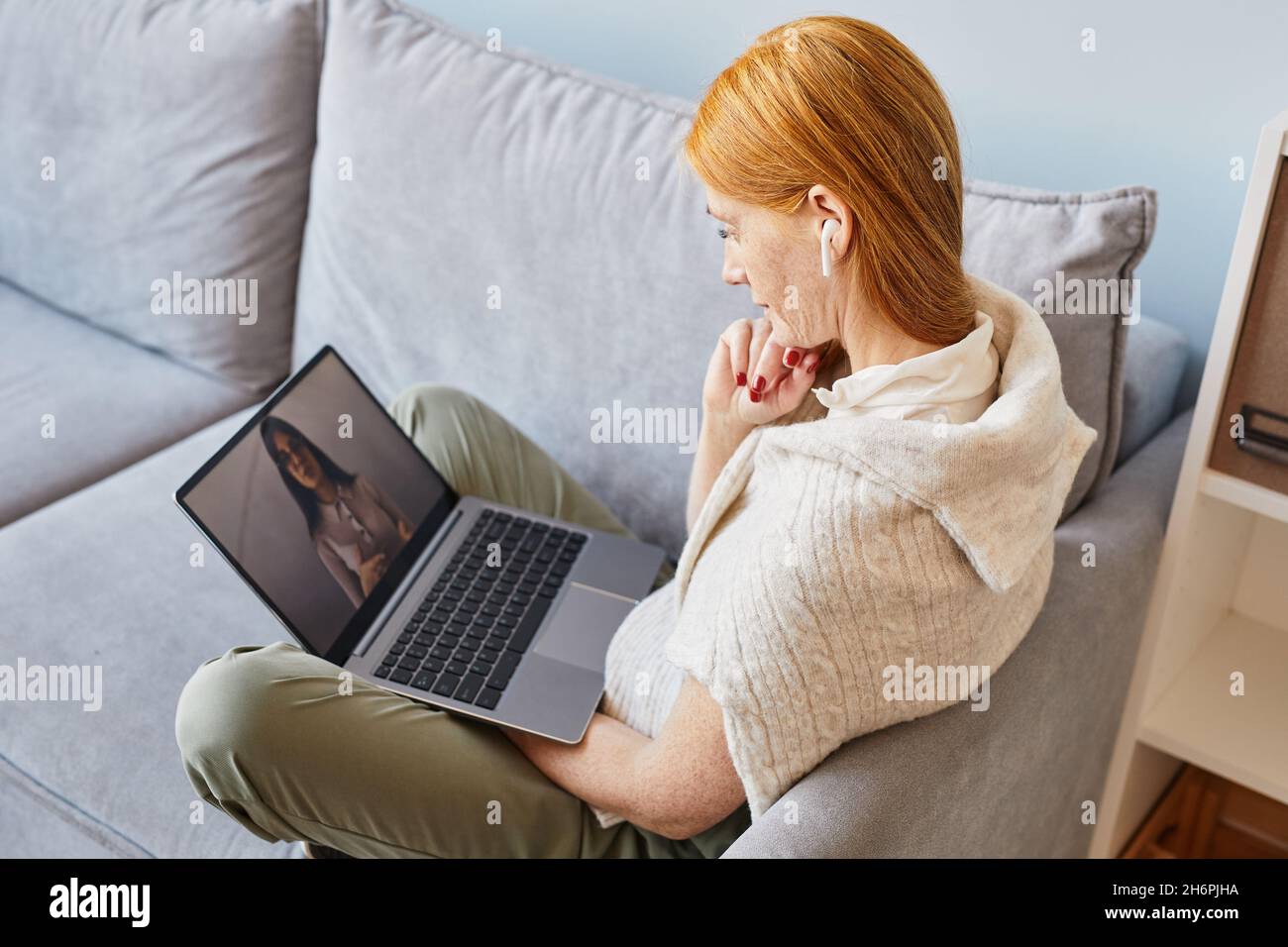 Seitenansicht Porträt einer rothaarigen jungen Frau, die einen Laptop benutzt, während sie zu Hause online studiert Stockfoto