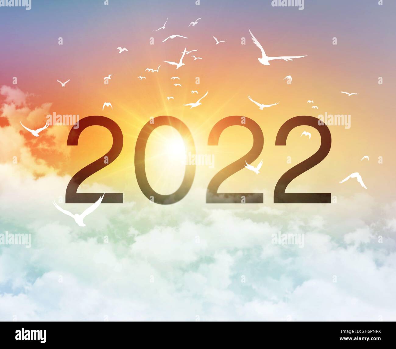 Neujahr 2022 Datumsnummer, in einem bunten schönen Himmel mit dem Morgenaufgang und einem Vogelflug, als Beginn eines neuen Tages Stockfoto