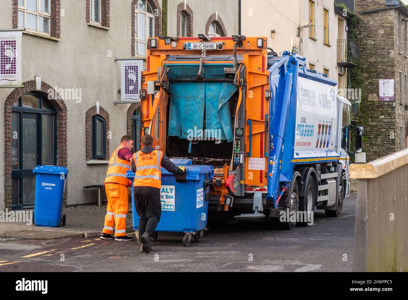 Müllmänner leeren Müll in einen Müllwagen in Bandon, West Cork, Irland. Stockfoto