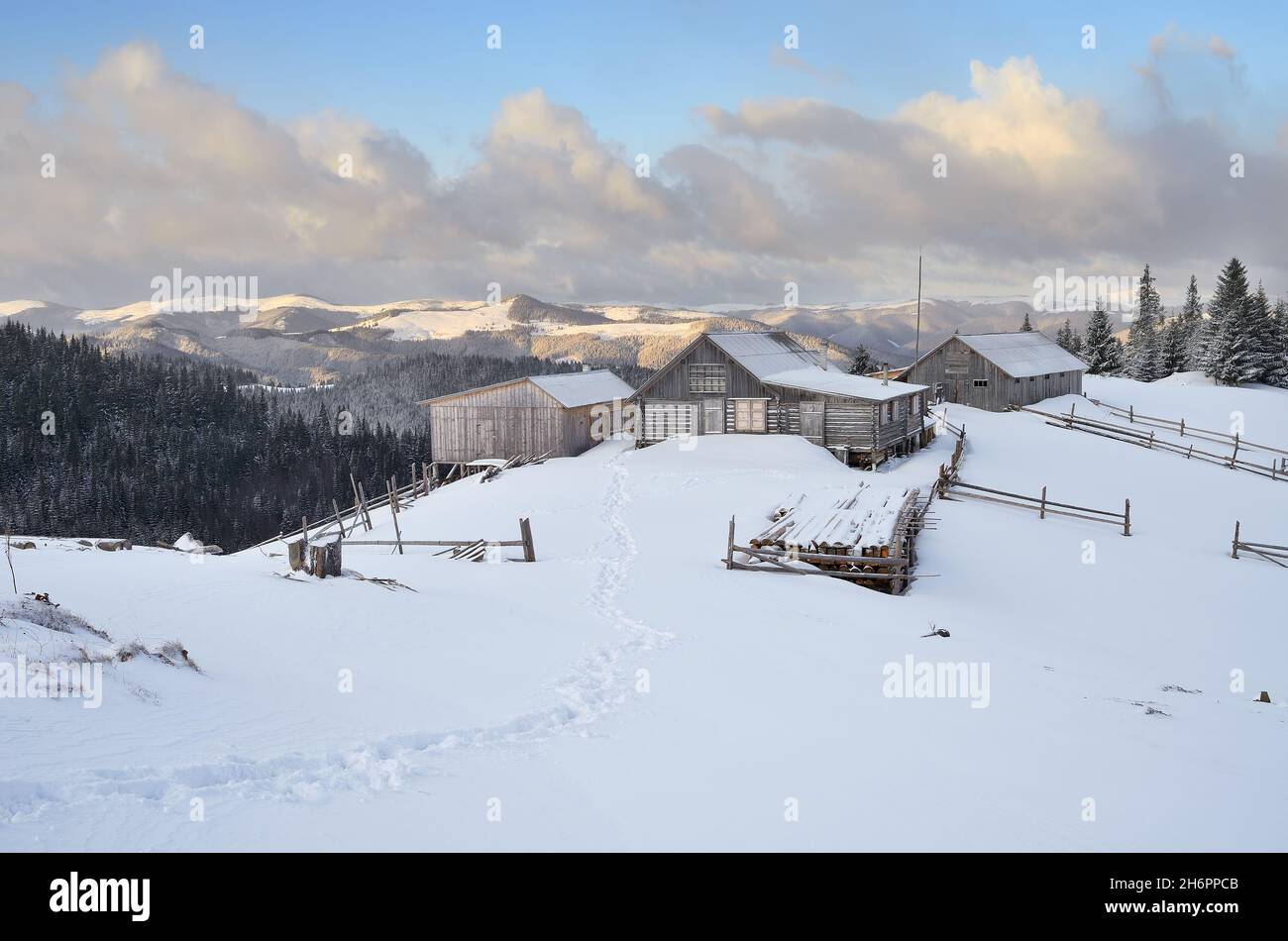 Winterlandschaft mit Bergdörfern. Holzhäuser auf einer verschneiten Wiese. Karpaten, Ukraine, Europa Stockfoto