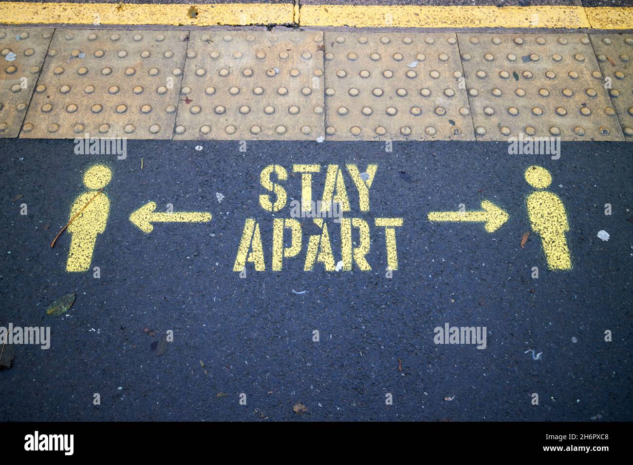 Bleiben Sie getrennt covid Einschränkungen auf einem Bahnsteig gemalt Liverpool merseyside uk Stockfoto