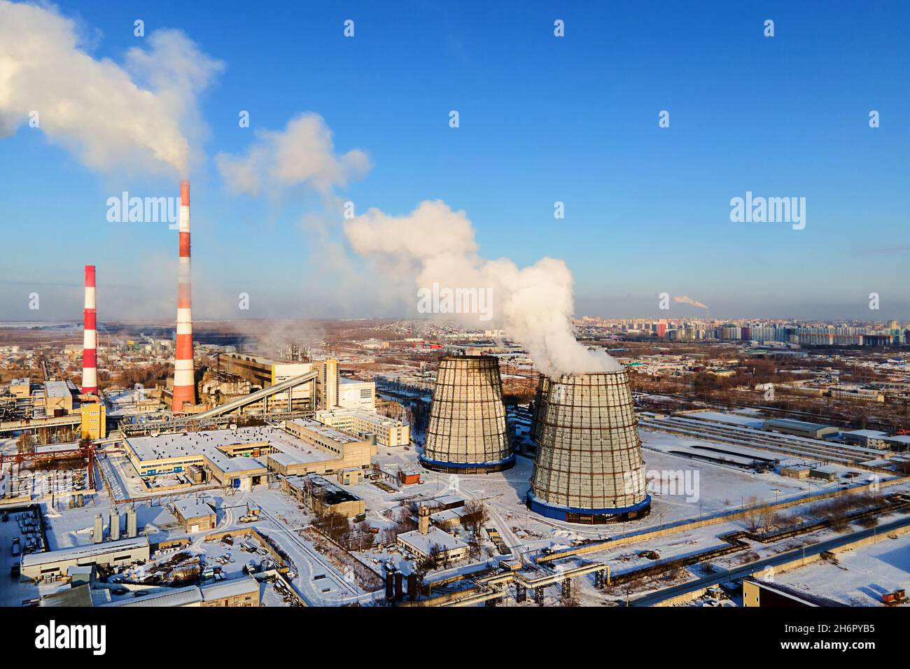 Blick auf die Rohre des Heizwerks von oben an klaren Wintertagen. Rauch kommt aus Schornsteinen. Heizen Stadt mit Erdgas im Winter. Beginn der Heizperiode. Hintergrund Stockfoto