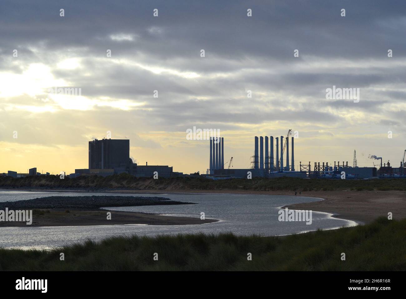 Atemberaubende Farbdarstellung mit Blick über Tees Bay auf das Kraftwerk EDF Hartlepool und die Windturbinen-Pole am benachbarten Able Seaton Port. Stockfoto