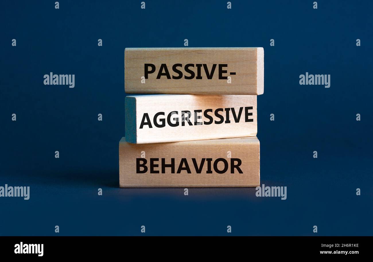 Passiv-aggressives Verhaltenssymbol. Konzeptwörter Passiv-aggressives Verhalten auf Holzblöcken. Schöner grauer Hintergrund. Business, passiv-aggressiv Stockfoto