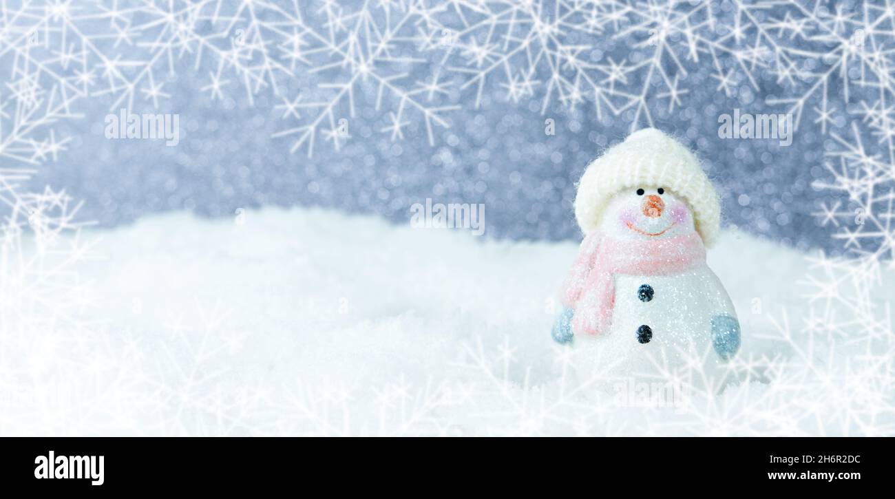 Weihnachten Hintergrund. Glücklicher Schneemann, der in einer weihnachtlichen Winterlandschaft steht. Frohe weihnachten und eine Grußkarte zum guten neuen Jahr. Lustiger Schneemann in einem Hut Stockfoto