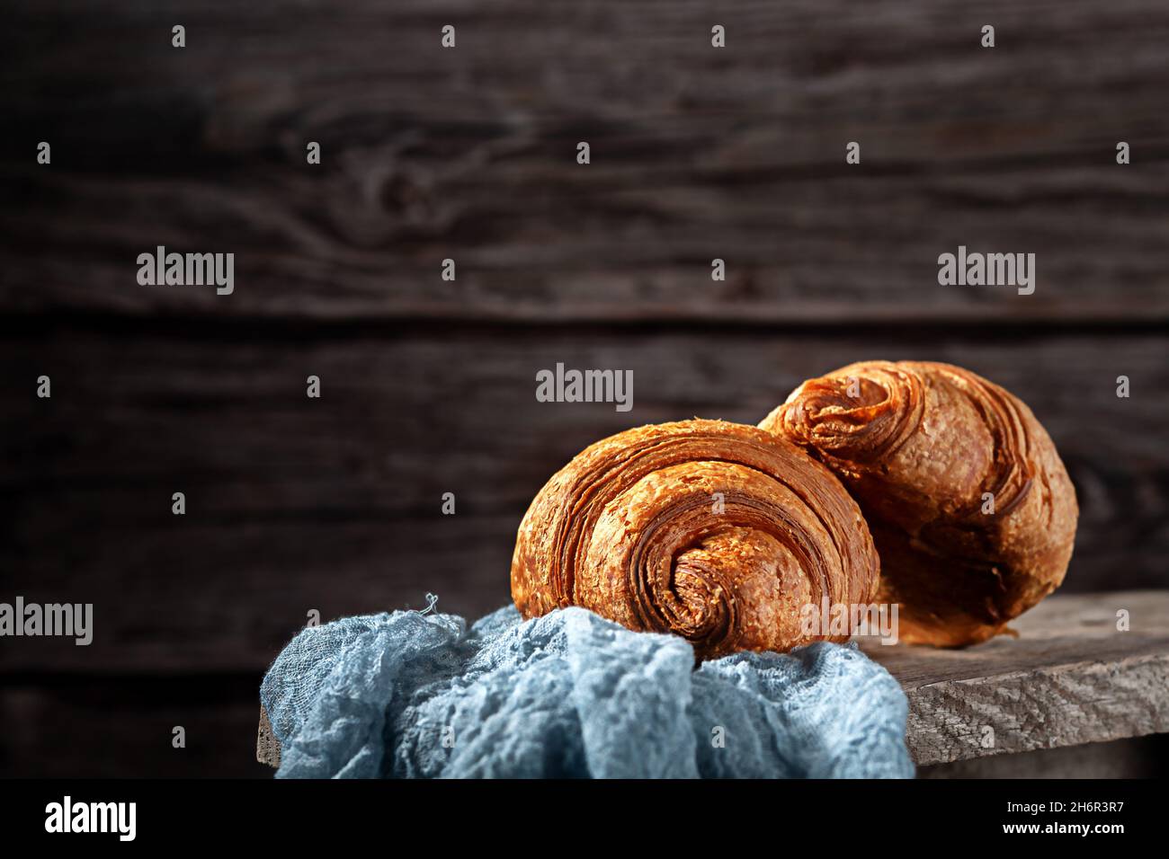 Frisch gebackene, duftende Croissants auf einem Holzhintergrund Stockfoto