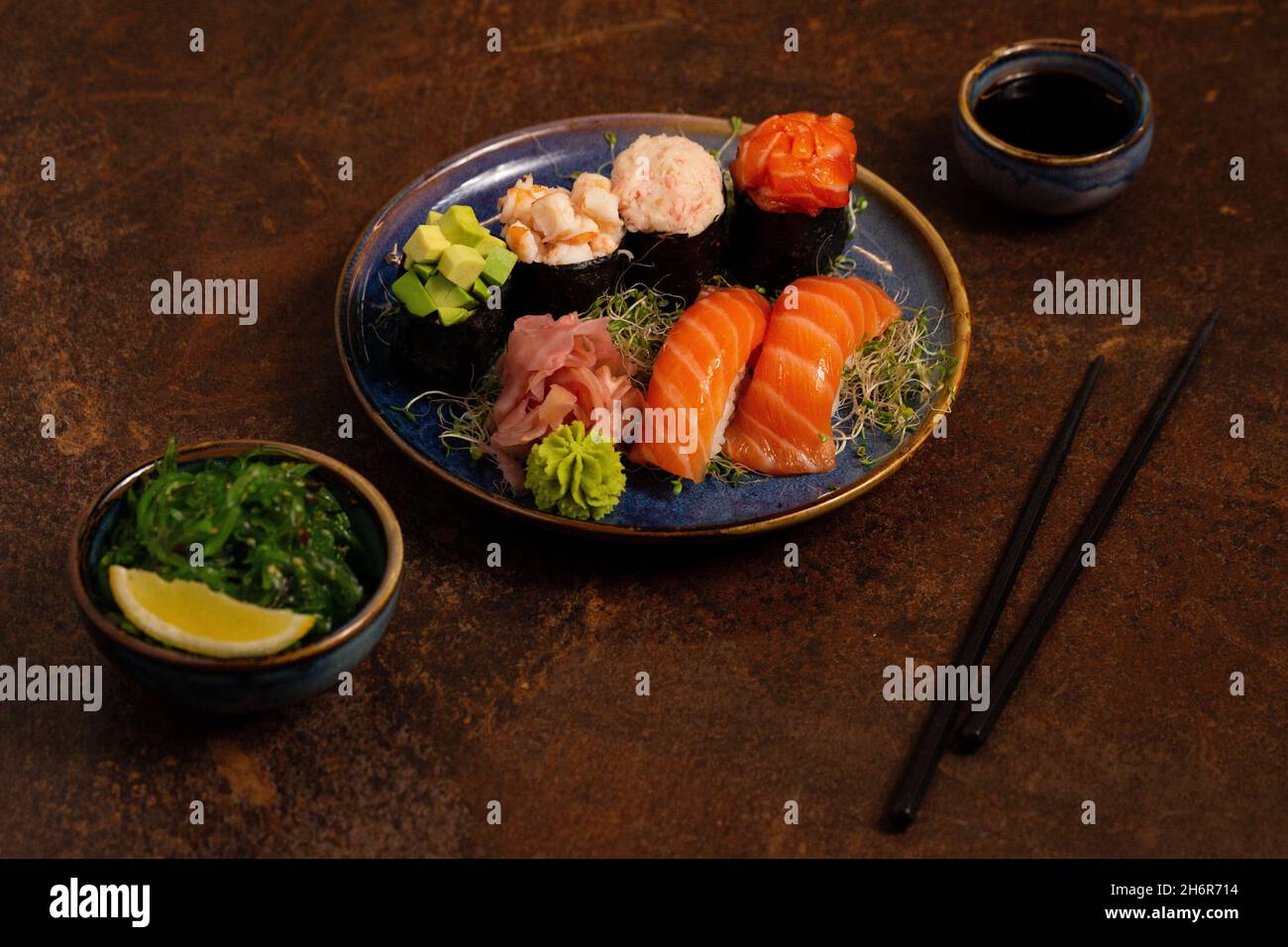 Sushi-Set, Sashimi, Rolls-Set auf dem Tisch. Asiatische Küche. Gesunde Ernährung. Wakame Salat und Sushi Sticks Stockfoto